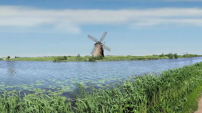 a landscape picture of the netherlands with a windmill