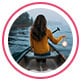 Profile image of reviewer, a woman sitting on rowboat and holding a paddle, facing the sea.