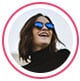 Profile image of reviewer, a woman wearing sunglasses and smiling while looking away.