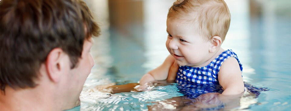 Man and the baby are swimming together