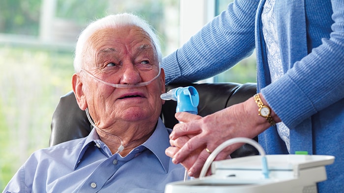 A man using the Philips InnoSpire Deluxe Compressor nebuliser system