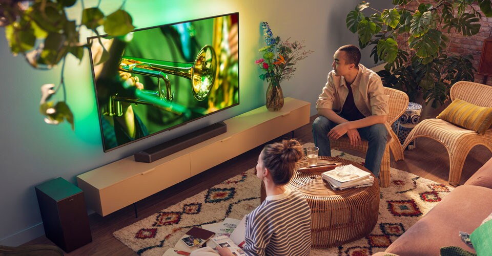 People enjoying their Philips Ambilight Tv with crisp soundbar sound