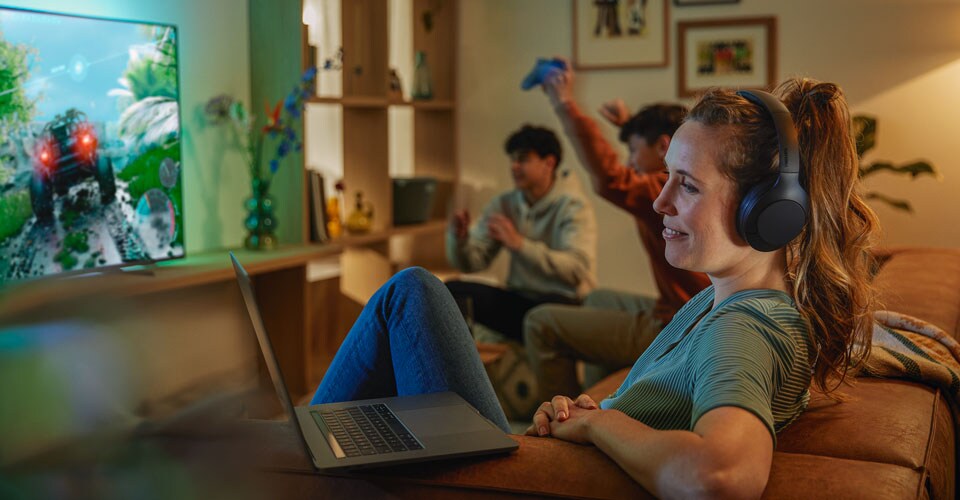 Woman wearing Philips over ear noise canceling headphones in a noisy room