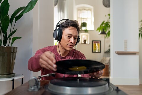 A man using Fidelio X3 headphones at home