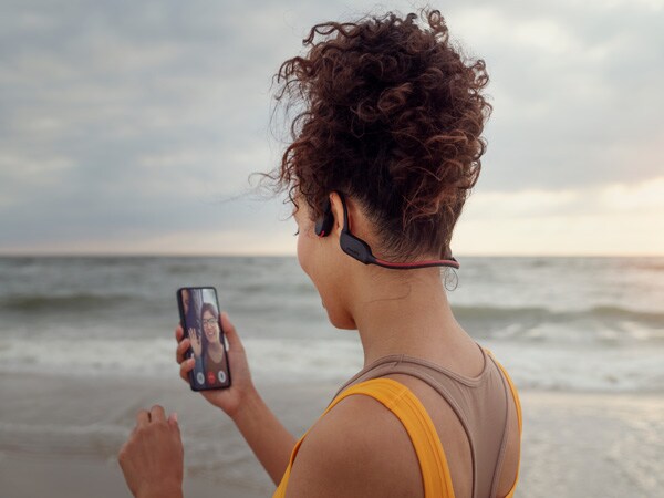 Woman enjoying crystal call feature of Philips bone-conducting headphones 