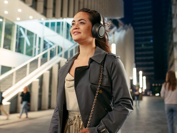 Woman enjoying comfort of Philips Fidelio headphones outdoor