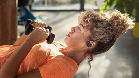 The woman using Philips true wireless sports earbuds at gym