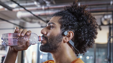 The man using Philips open-ear bone conduction headphones at gym