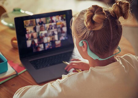 Close-up image of girls attending class using Philips open-ear kids headphone