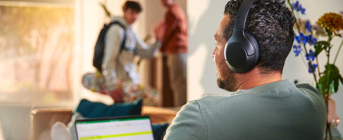 Man using Philips Noise cancelling headphones while working