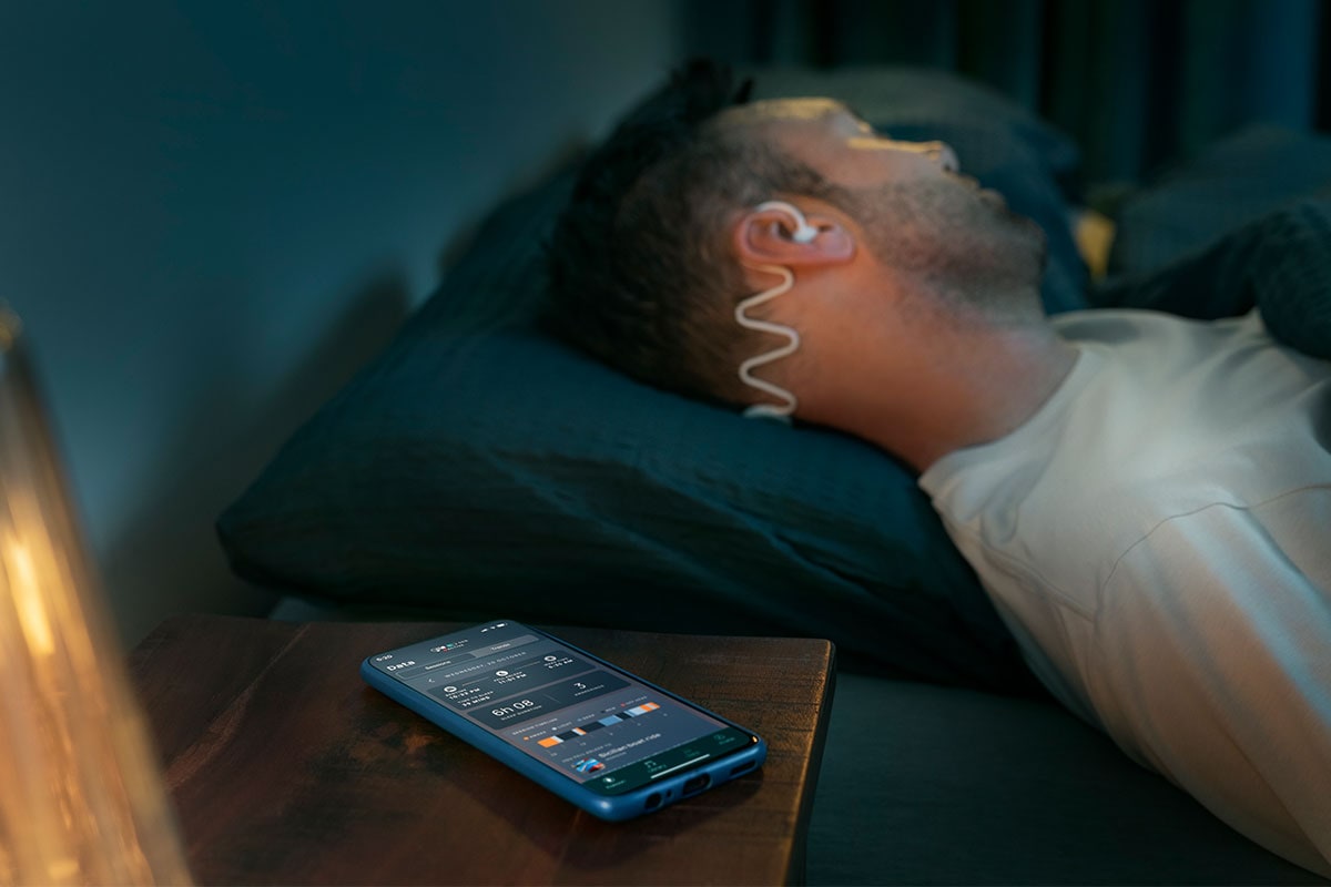  Man sleeping with Philips Sleep Headphones and the Kokoon app.