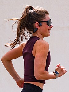 Runner woman wearing bone conduction headphones