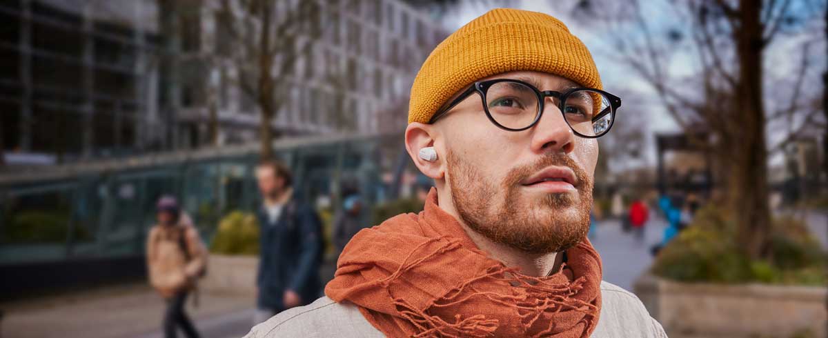 Close-up photo of a man wearing true wireless headphones