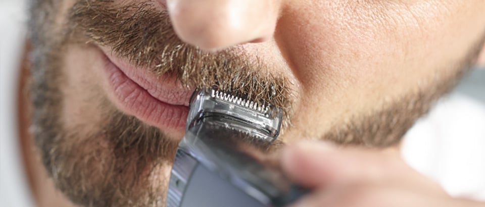 Man trimming moustache with Philips beard trimmer