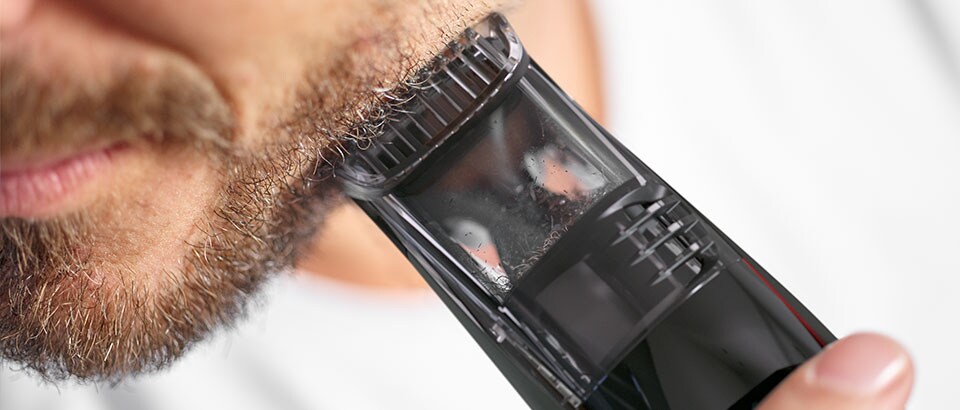 Man trimming beard with Philips vacuum beard trimmer