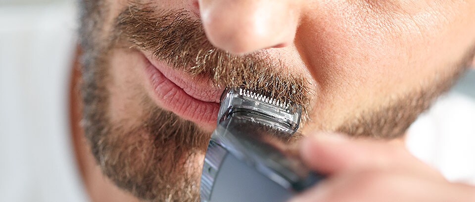 Man trimming moustache with Philips beard trimmer