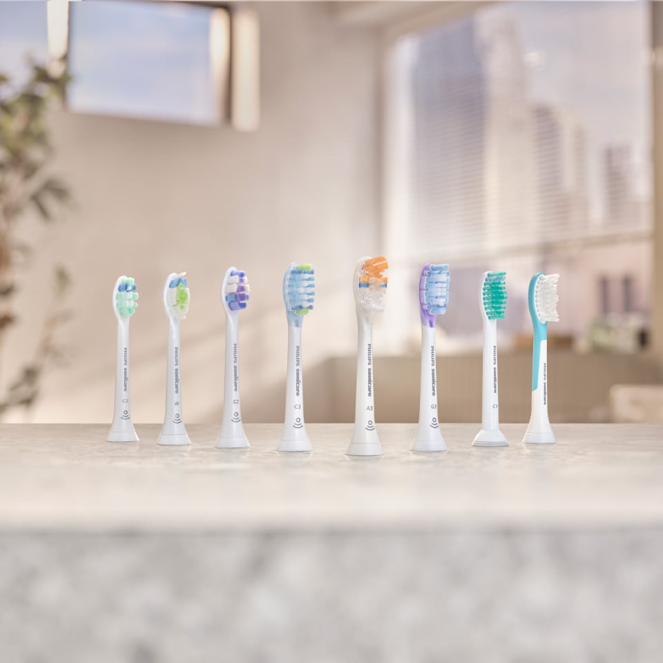 Sonicare power toothbrushes aligned on a countertop