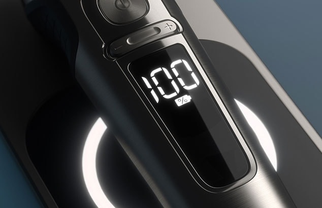 A black and silver electric Philips shaver displaying 100% battery.