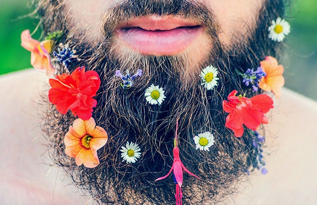 Closeup of a man’s beard that has lots of different and colourful flowers added to it.