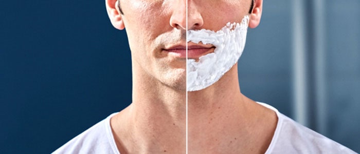 Left side of a clean-shaven man’s face and right side of the same man with shaving foam on lower face.