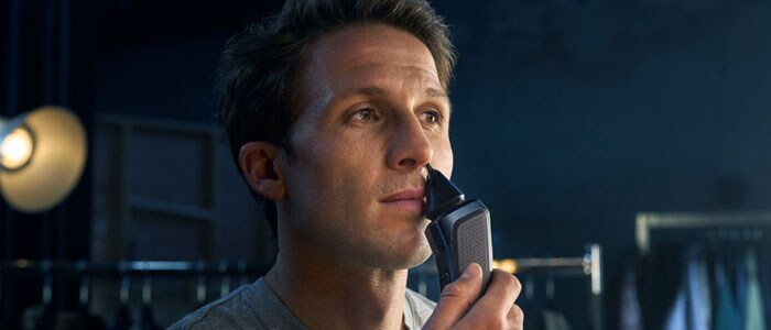 Photograph of a man removing his nose hair with a Philips Nosetrimmer