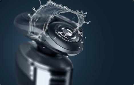 A close-up photograph of a Philips rotary shaver head with a splash of water to highlight its wet shaving capability