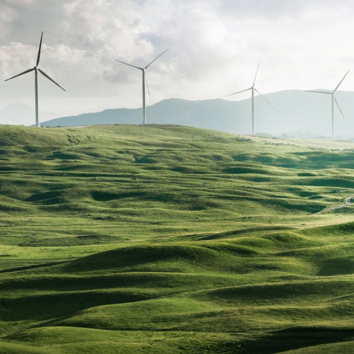 A wind farm with green hills, to represent clean energy and sustainability in businesses