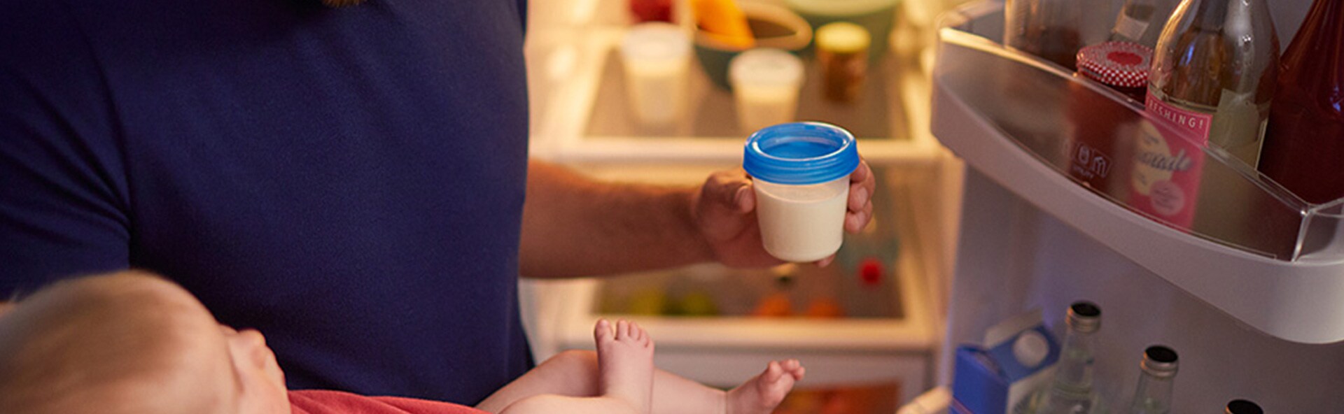 A person putting milk in the fridge