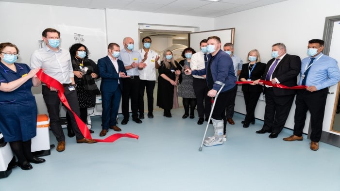 Heartlands Treatment Centre first patient, Richard Mullen cuts a ribbon with UHB staff present to celebrate the occasion