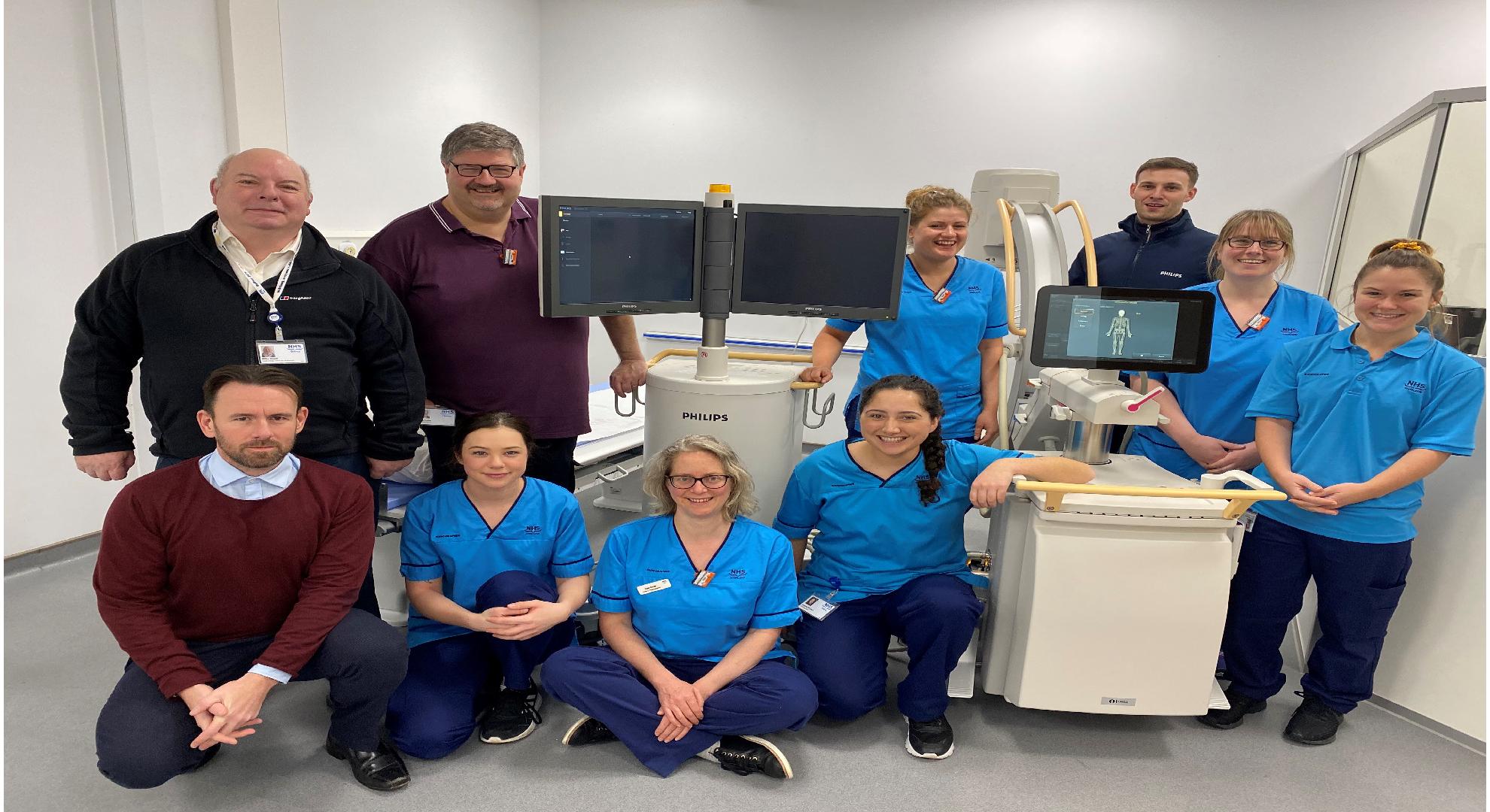 Download image (.jpg) Shown left to right, back row, standing: Mike Beach, Radiology Services Manager; Nick Crohn and Rebecca Drever, Radiographers; Duncan Rennie, Customer Support Engineer, Philips UK, with Radiographers, Jenna Prestwood  and Erin Connell Seated and kneeling, front row, left to right: Simon Bunce, Interventional Product Manager, Mobile Surgery, Philips UKI with Radiographers Kaia McDonald, Katie Smith and Kamea Wi Repa (opens in a new window)