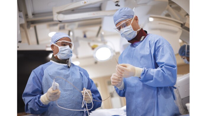 Two healthcare professionals in exam room holding the Philips VeriSight catheter