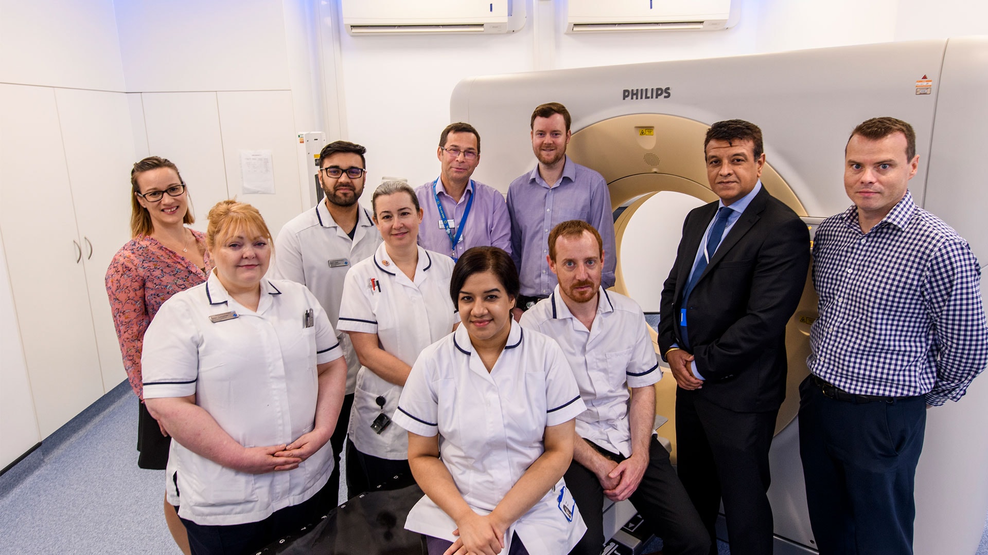 Download image (.jpg) Shown left to right, Hannah Timbrell, Business Marketing Manager, Philips UKI; Helen Corbishley, Pre treatment Advanced Practitioner; Wasim Ajaib, Senior Radiographer; Sarah Jhally, Pre treatment Superintendent; Stephen West, Head of Radiography; Doug Northover, Clinical Scientist; Pete Bains, Account Manager and Jon Brigly, Marketing Manager, both of Philips UKI.   Seated in front on the left is Aisha Sajid, Pre treatment Team Leader and on the right is Joshua Bayley, Pre treatment Team Leader (opens in a new window)